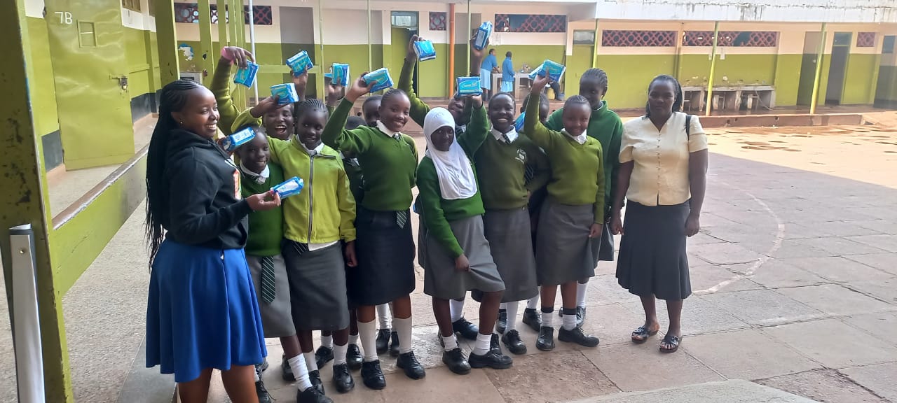 Students at Olympic Junior Secondary School proudly holding sanitary products received from Period Pride Kenya